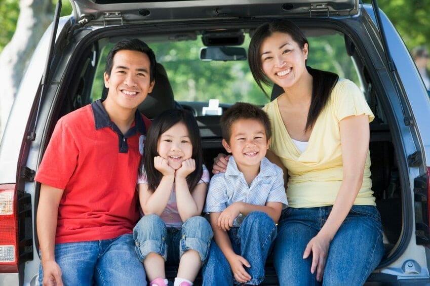 A family sitting in the trunk of a car, traveling to Kauai.