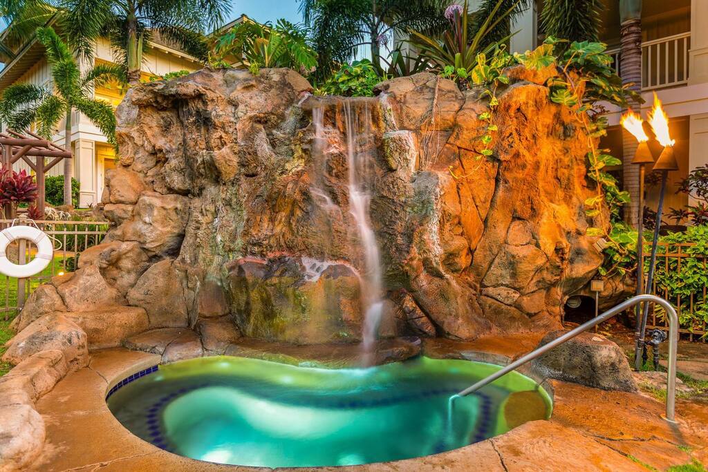 Scenic hot tub featuring a waterfall and rocks at Kauai Villas.