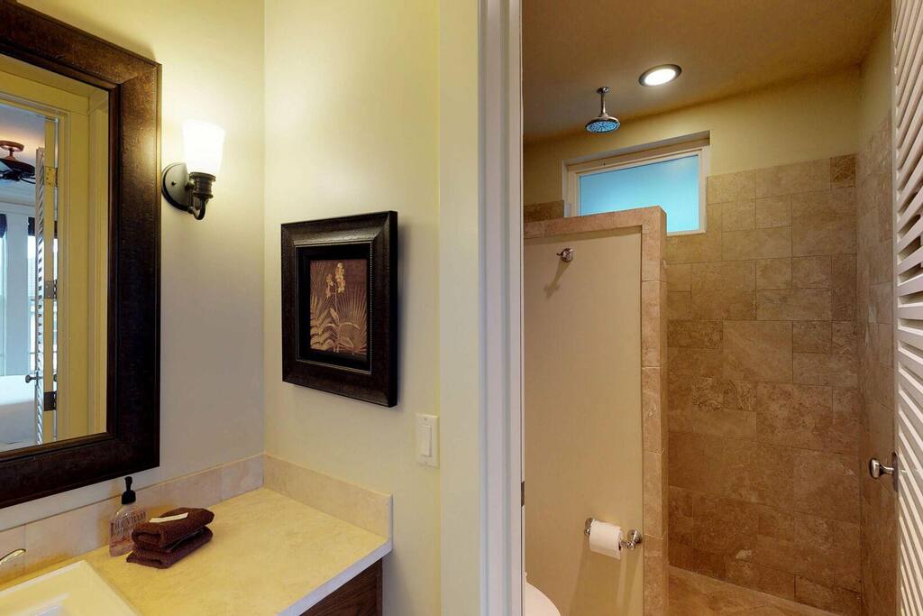 Modern bathroom with shower and sink at Kauai Villas.
