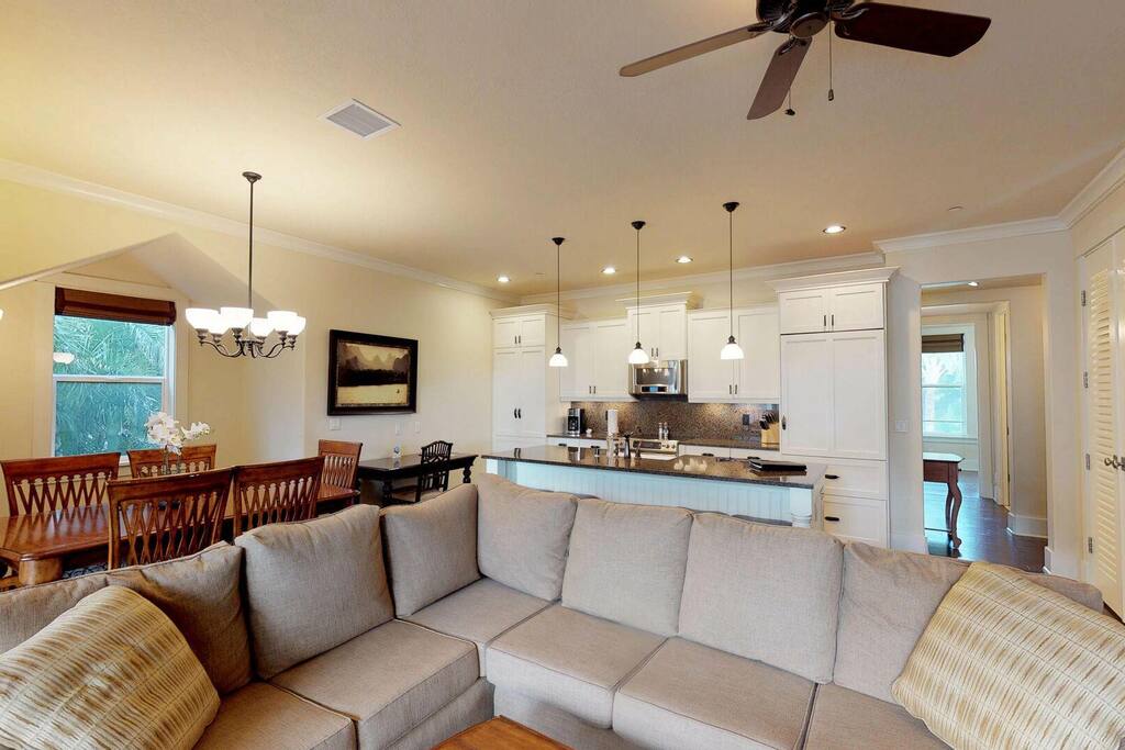 A cozy living room at Kauai Villas, featuring a comfortable couch, a stylish table, and a ceiling fan.